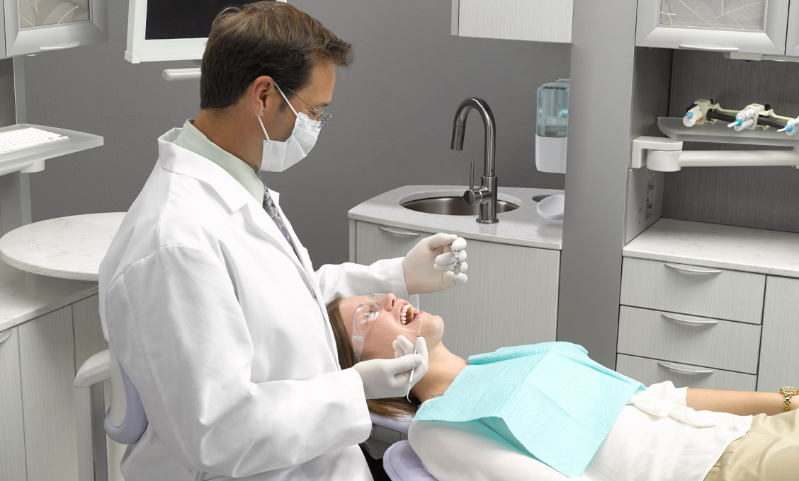 Dentist attending to patient in A-dec dental equipment operatory 